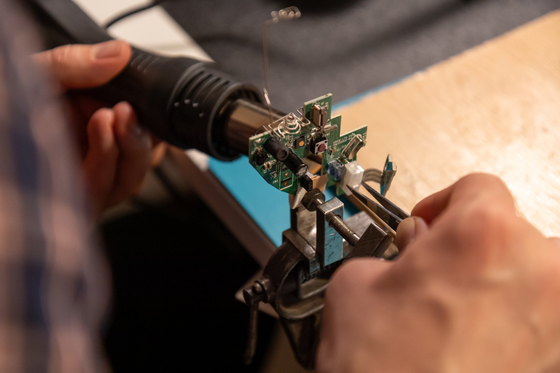 Electronics technician repairing printed circuit board in laboratory