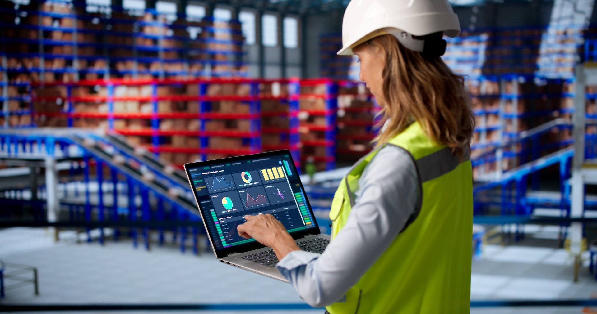 Mature Woman Uses Laptop To Track Warehouse Inventory And Improve Logistics