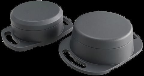 Two gray cast iron cookware pots with lids and handles on black background
