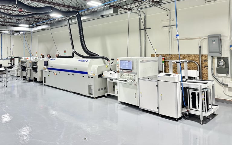 Industrial printing or manufacturing equipment in a clean warehouse facility with polished floors and overhead utilities