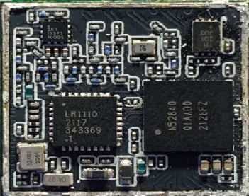 Close-up of electronic circuit board with integrated chips, resistors, and various components on dark PCB